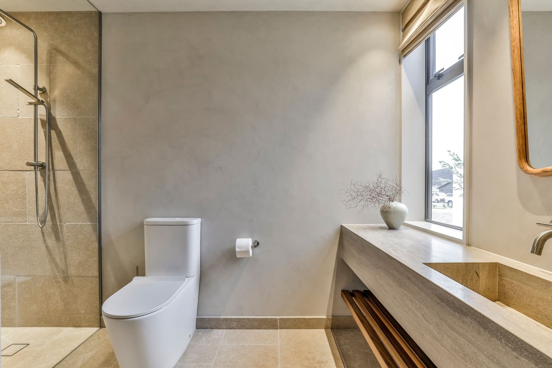 Bathroom with a stone-topped vanity shelf, limestone floor and window