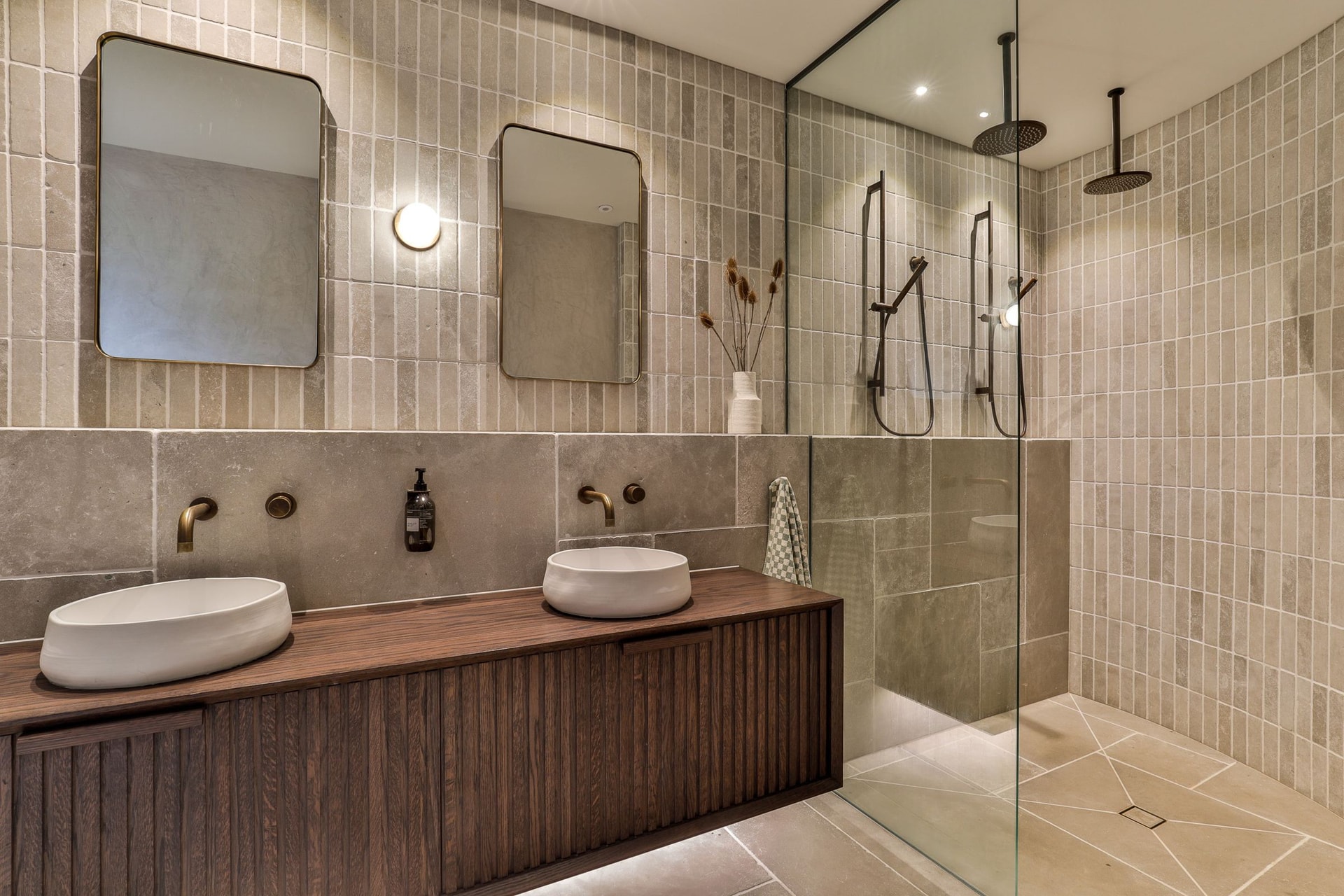 Ensuite with a dark fluted oak vanity, two basins and a curved walk-in shower lined in grey stone finger tile